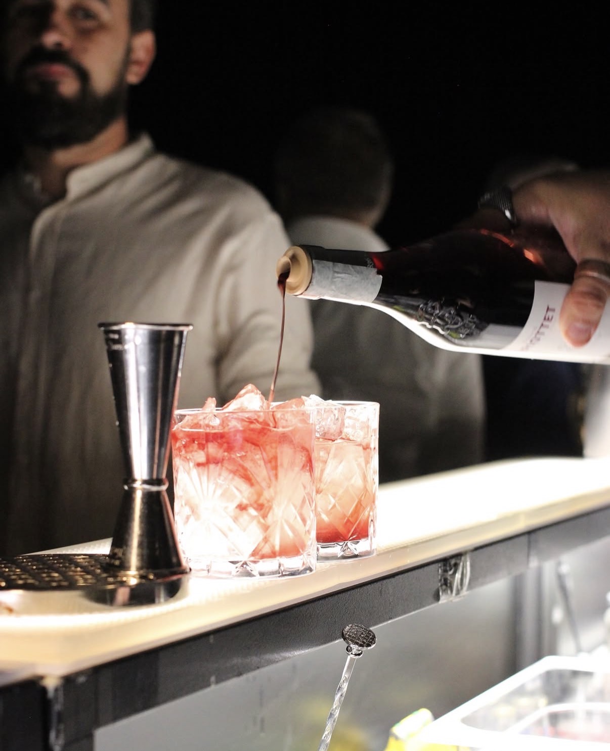 Bartender versa vermouth in due tumbler con ghiaccio