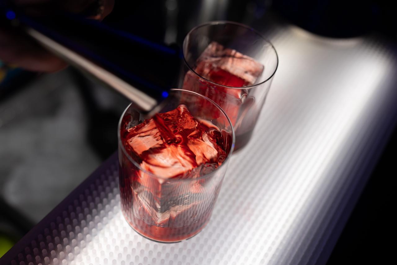 Due tumbler con cocktail rosso e ghiaccio