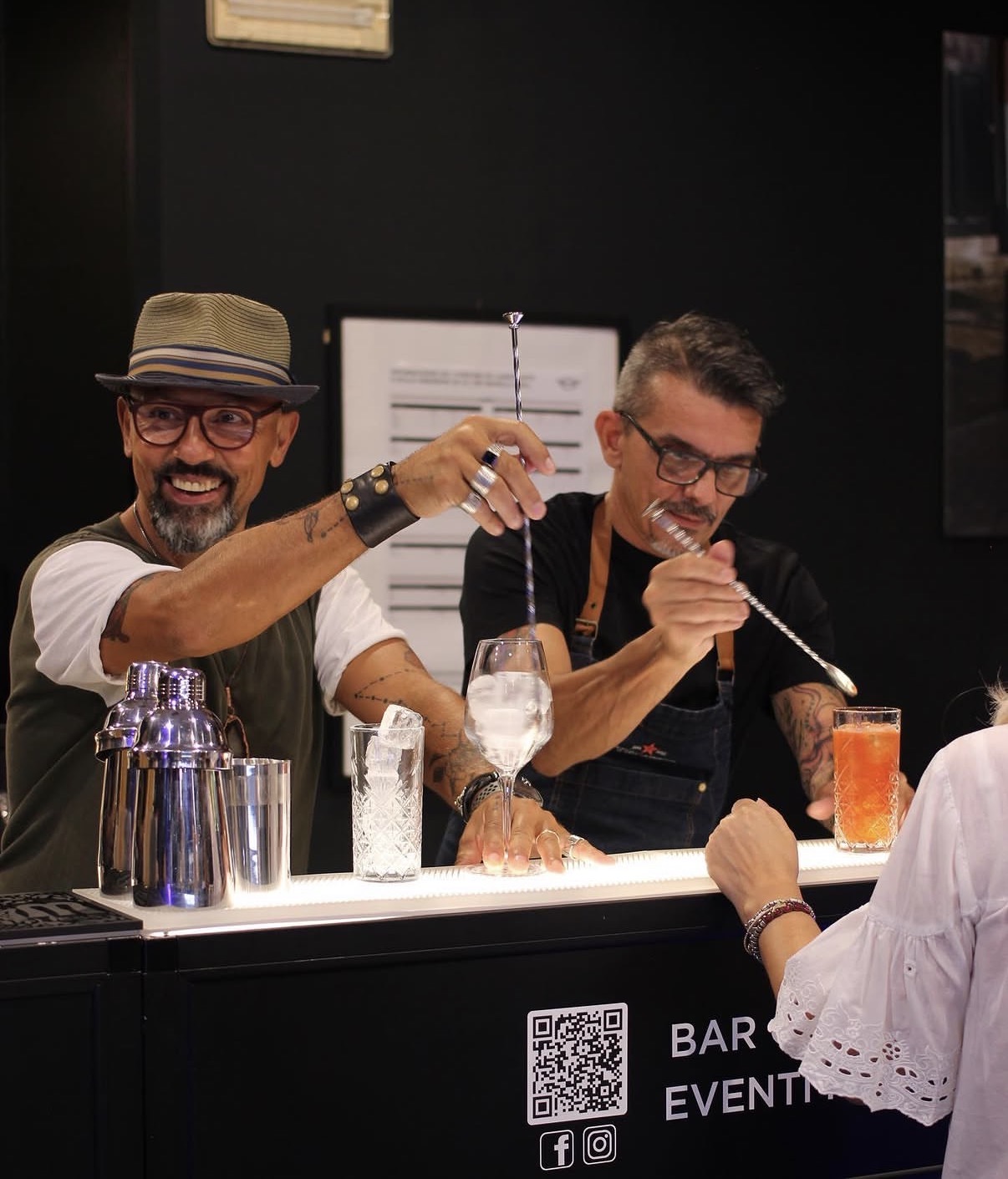 Due bartender preparano cocktail al bancone