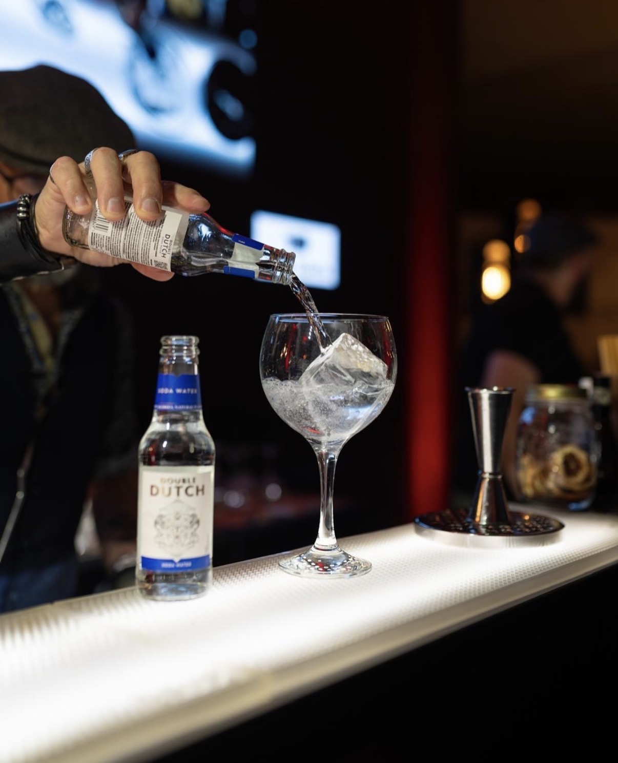 Gin tonic con bottiglia di tonica al bancone