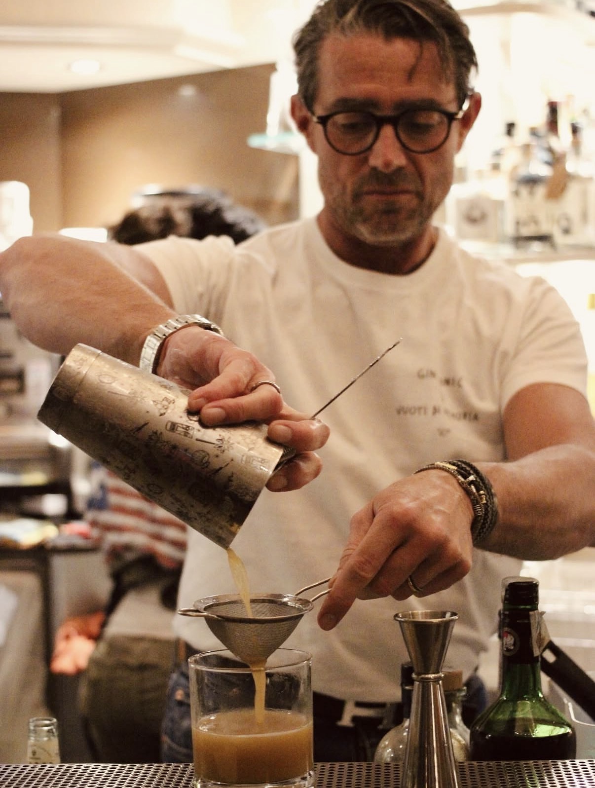 Bartender filtra un cocktail attraverso un colino